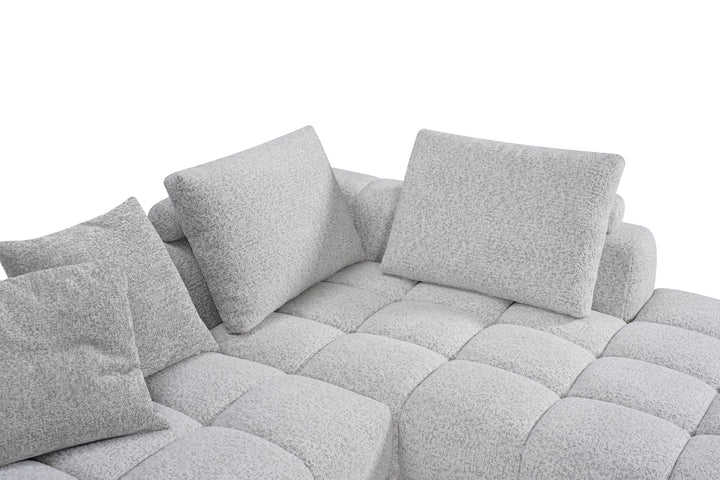Comfortable modular sofa in a neutral fabric, featuring plush cushions and a modern design for versatile living room seating.