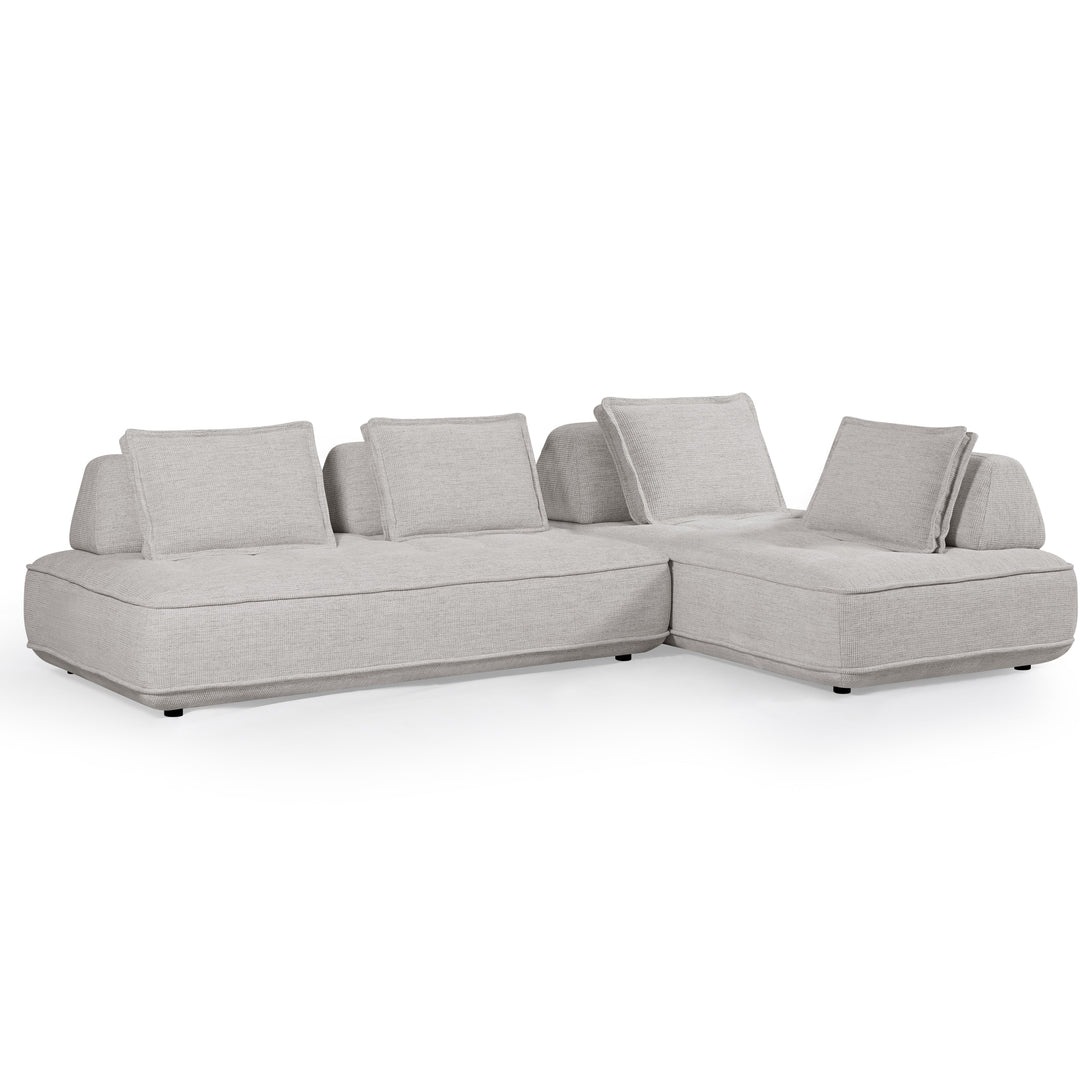 Cozy modular sofa with plush cushions and neutral fabric, arranged in a modern living room setting.