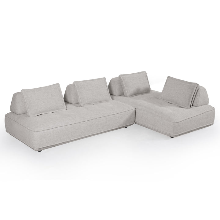 Cozy modular sofa with plush cushions and neutral fabric in a modern living room setting.