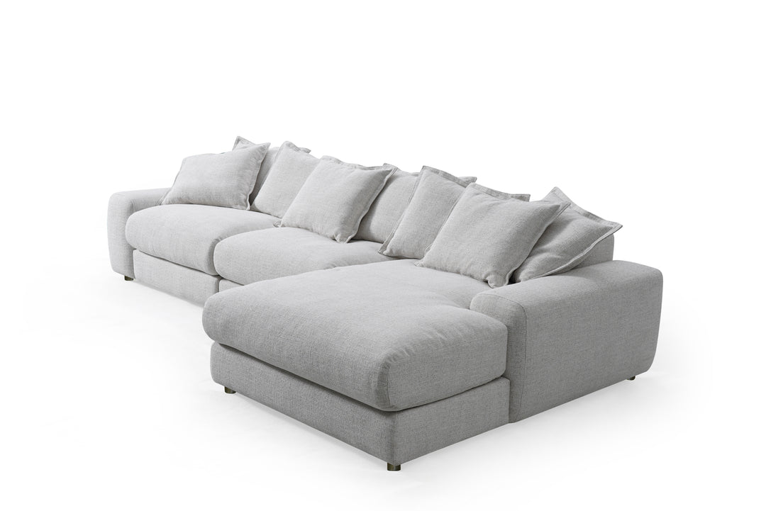 Corner sofa in neutral fabric with plush cushions, designed for comfortable lounging in a modern living room setting