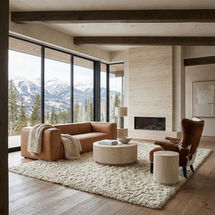 Three-seater Lexington tan leather sofa with plush cushions, paired with a cowhide accent chair in a modern living room setting.