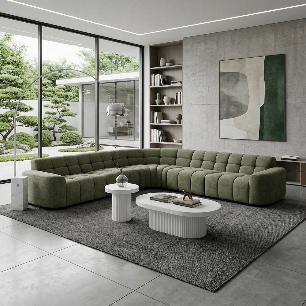 Moss green Adriano corner sofa with plush cushions and modern design, shown from a side angle in a living room setting.
