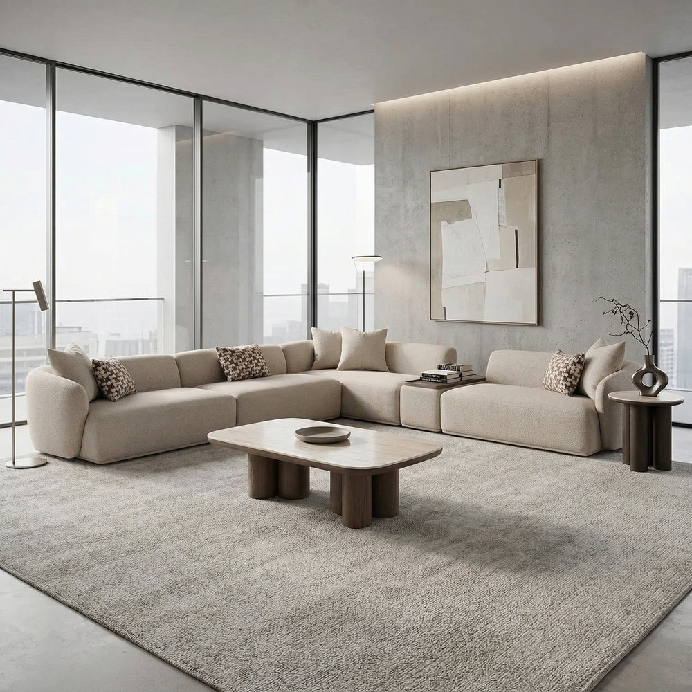 Modular sofa with beige upholstery and clean lines, paired with a glass coffee table in a modern living room setting.
