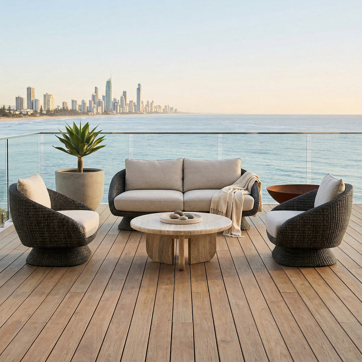 Grey outdoor sofa from Kipos with plush cushions, ideal for patio seating, shown on a travertine surface with outdoor furniture.