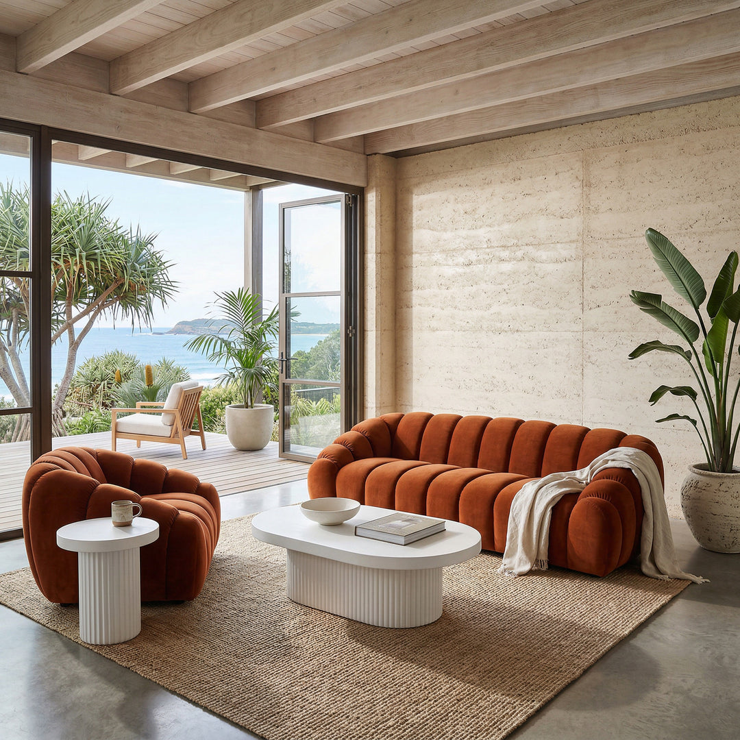 Oval Bondi Coffee Table with wooden finish, placed in a living room setting with a sofa and chair nearby.
