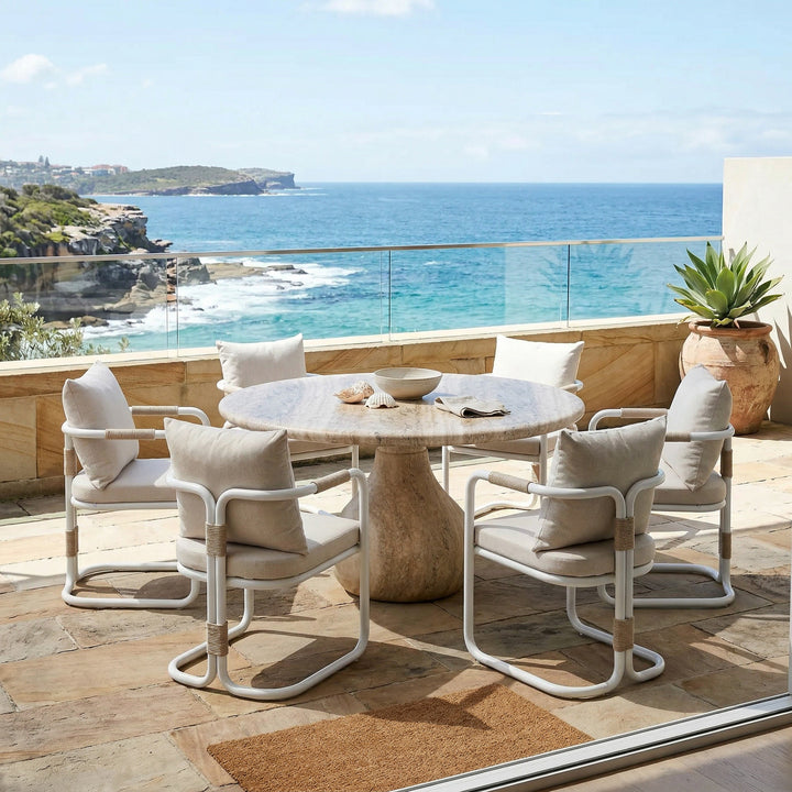 Round Aqua dining table with travertine finish, 1.5m diameter, paired with four matching chairs for outdoor dining.