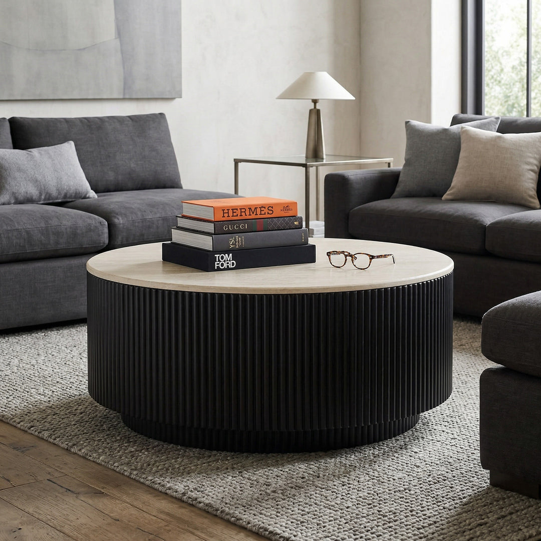 Round Noosa Coffee Table with a wood finish, placed in a modern living room setting with a neutral-toned rug and decorative accessories.