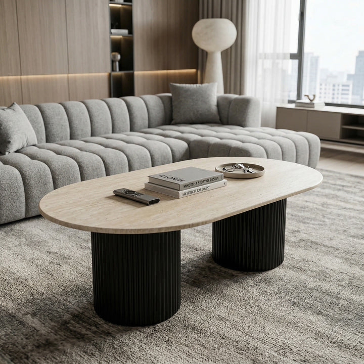 Noosa Oval Coffee Table with travertine top shown alongside a sofa, featuring a sleek, modern design for contemporary living spaces.