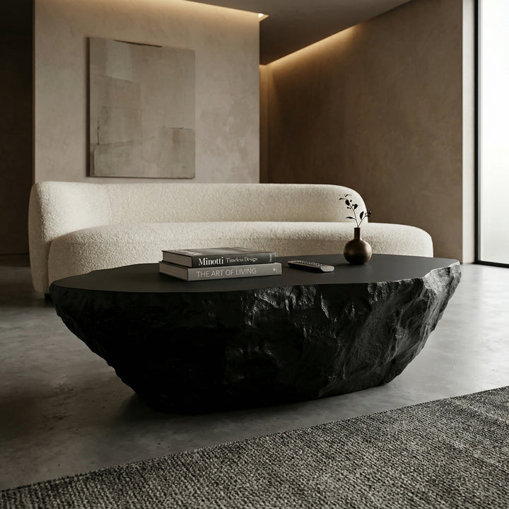 Black Roccia coffee table with sleek design, paired with a sofa in a modern living room setting.