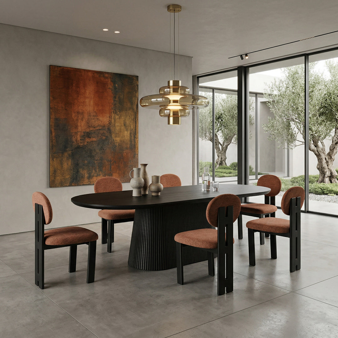 Terracotta Yarra dining chair with wooden legs, shown next to a black oak oval dining table in a modern dining room setting.