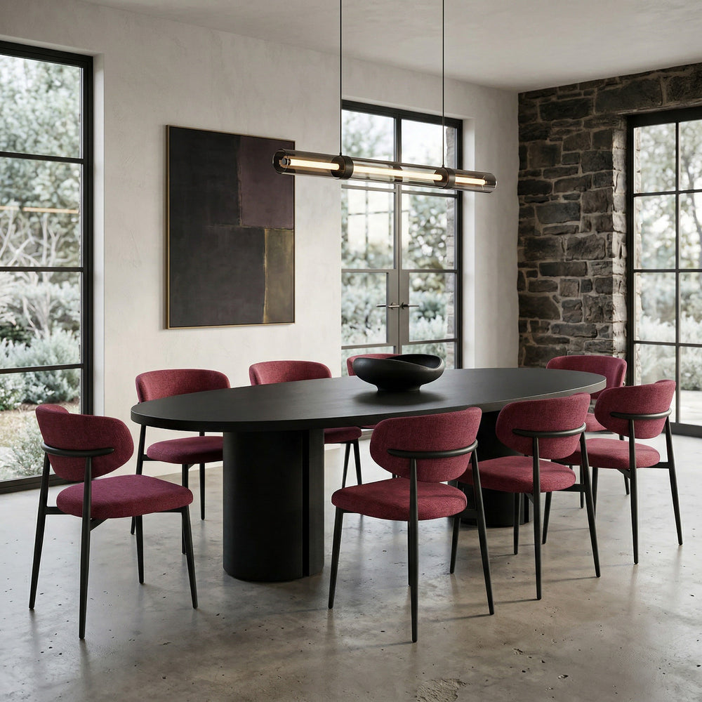 Black oval dining table with a sleek surface, set against a background featuring the Valentina Plum dining chair.