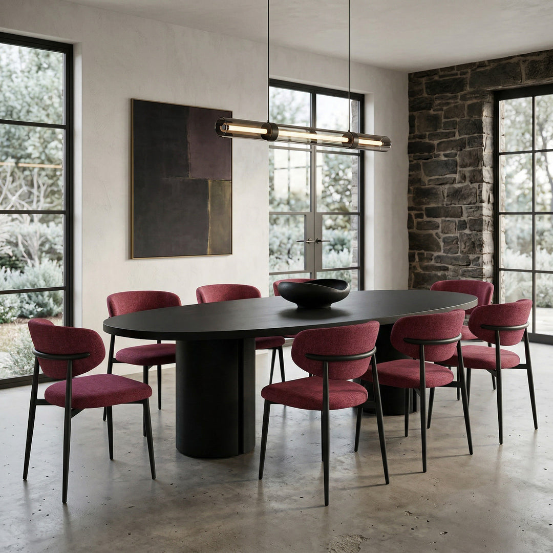 Black oval dining table with a sleek surface, set against a background featuring the Valentina Plum dining chair.
