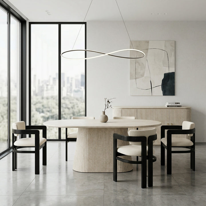 Beige Calabria dining chair with a sleek design, positioned next to a travertine dining table and buffet in a modern dining room.