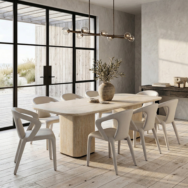 Light grey/beige leather-look profile dining chair with modern design, shown next to a travertine rectangular dining table.