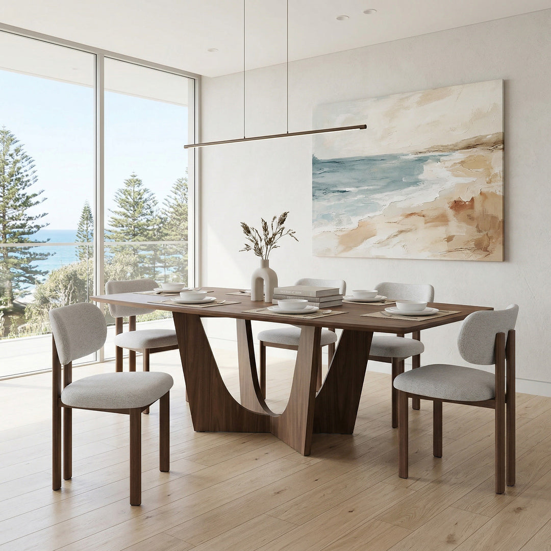 Beige Sabbatini dining chair with wooden legs, shown next to a large walnut dining table in a modern dining room setting.