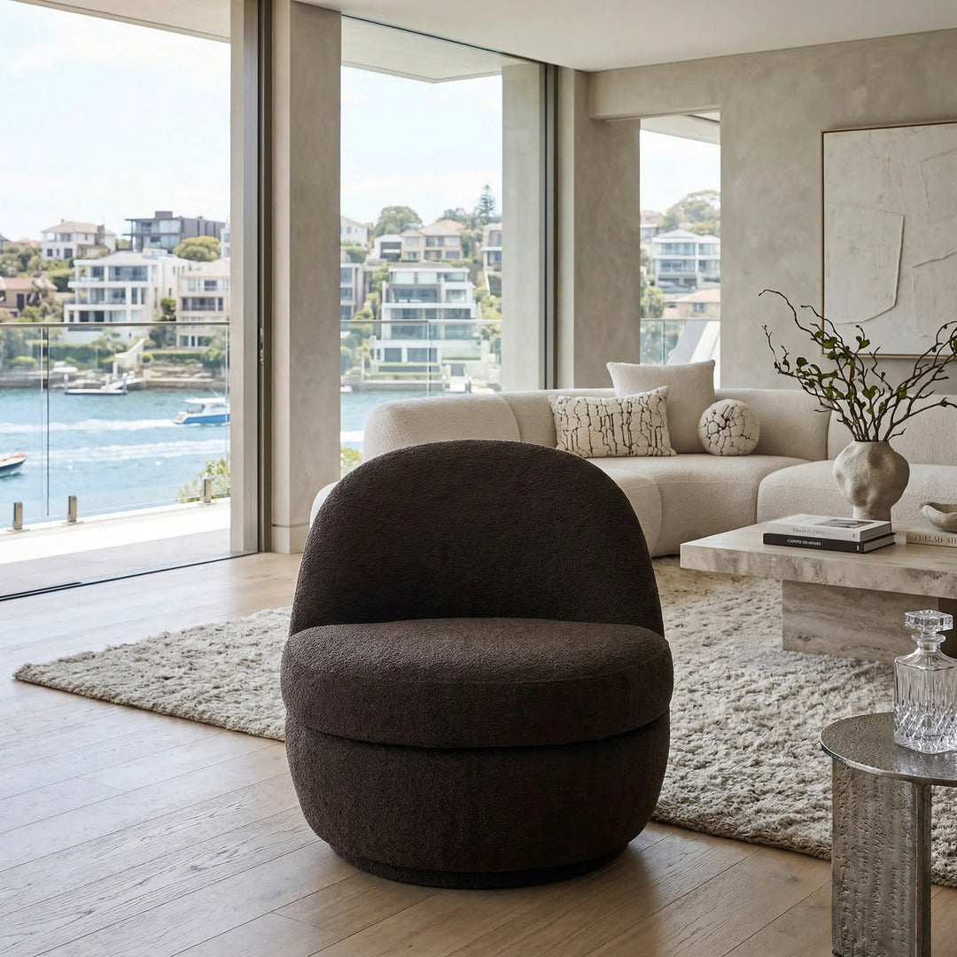 Chocolate Lusso Swivel Chair with a sleek modern design, featuring a rounded shape and plush upholstery in a contemporary living room setting.