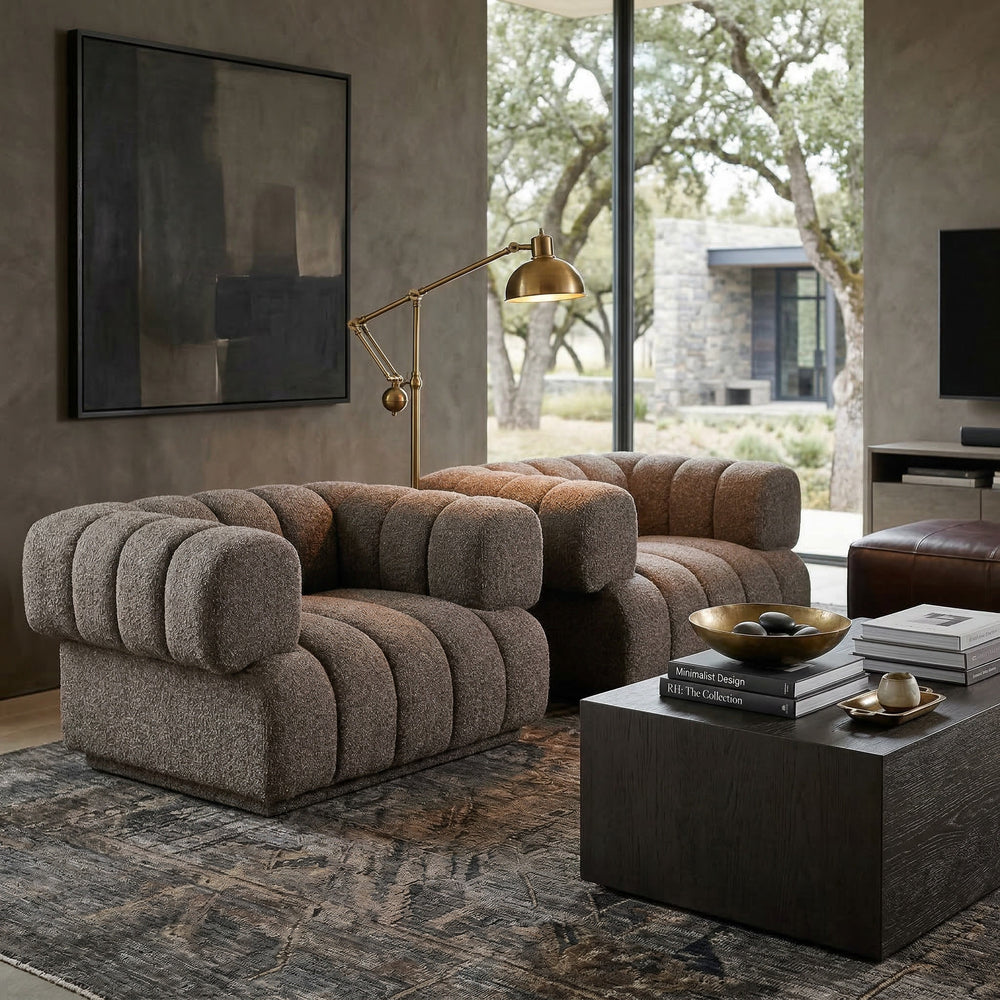 Modern Sardinia Chair, a stylish occasional chair with a rounded banana-shaped design in neutral upholstery, placed in a contemporary living room.