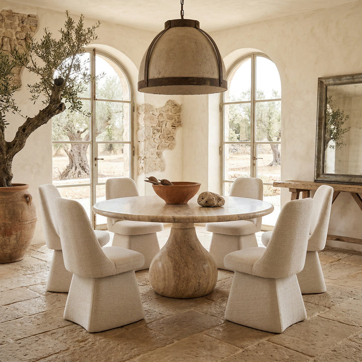 Modern Coolum Dining Chair with sleek design, shown alongside a round travertine dining table, perfect for contemporary dining rooms.