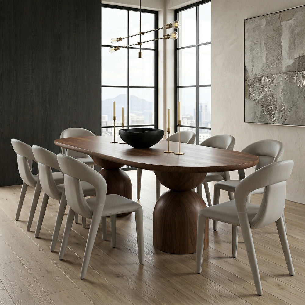 Walnut tulip-shaped oval dining table with smooth surface, paired with dining chairs, in a well-lit modern dining room setting.