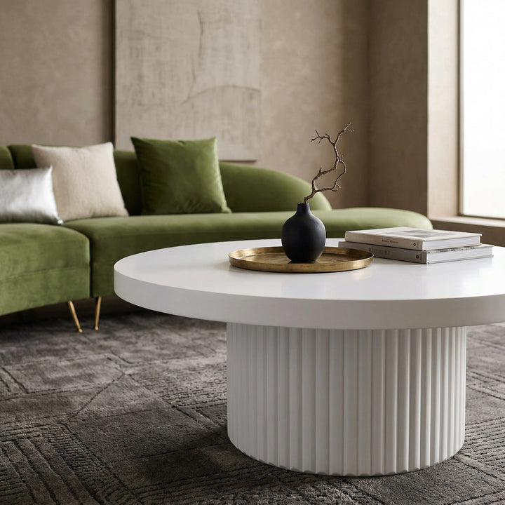 Round white Bondi coffee table paired with a green velvet sofa in a modern living room setting.